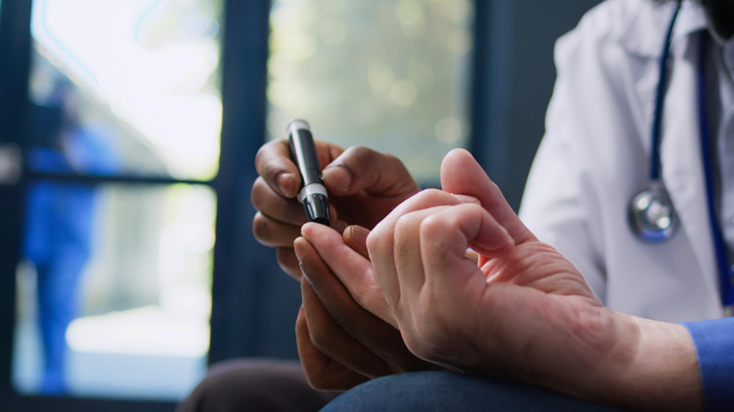 74496 A doctor checks a patient's blood sugar by pricking their finger with a small device.